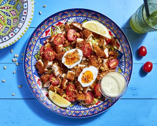 Salade César au schnitzel, œufs durs, tomates cerises et sauce